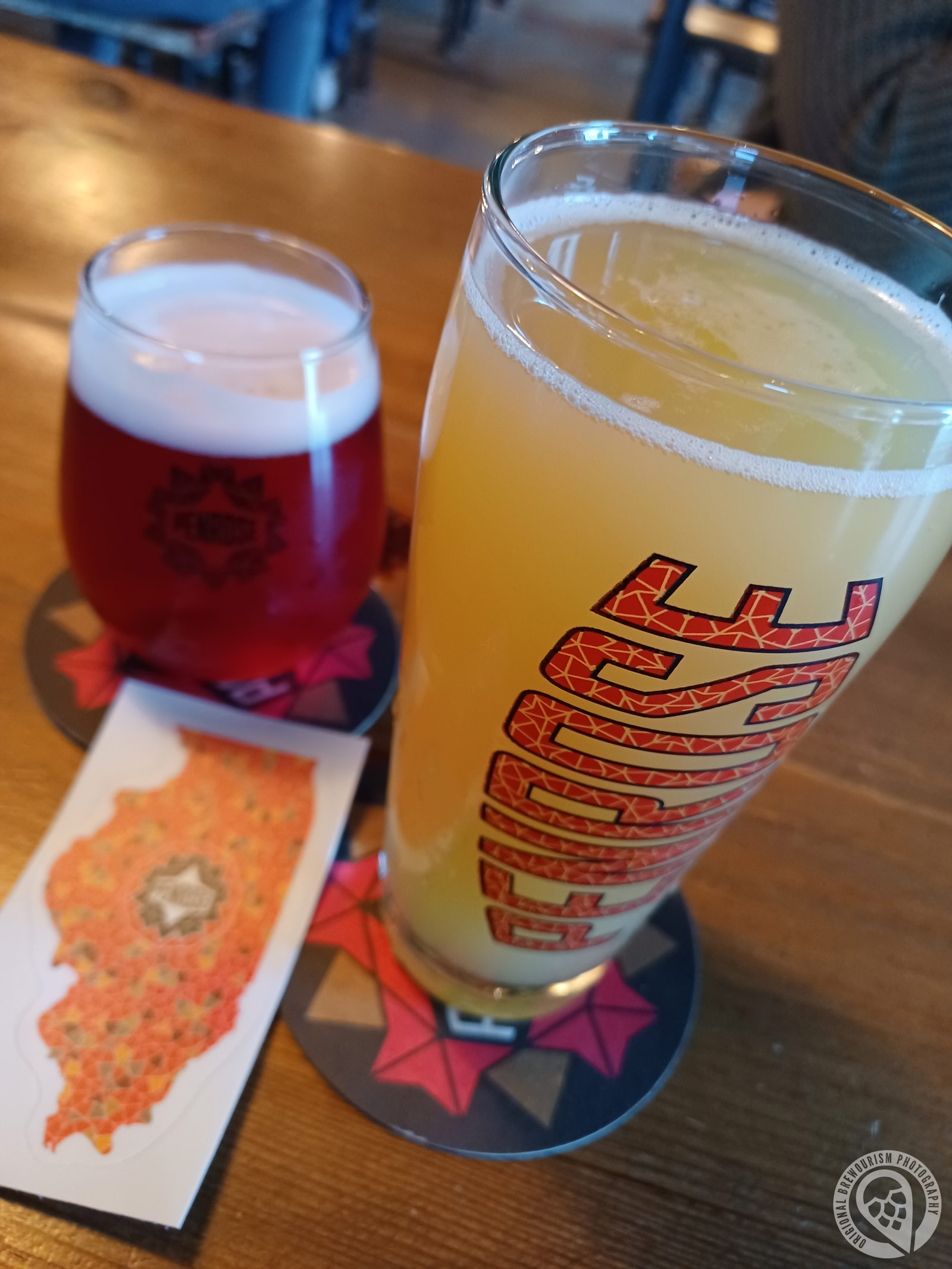 Two pints of beer, a sticker, and a coaster from Penrose Brewing